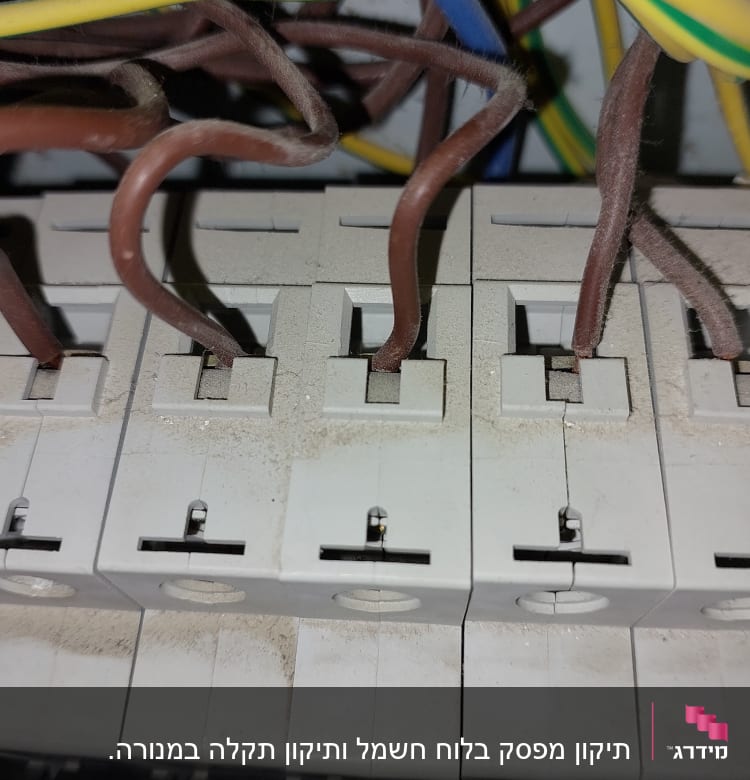 חוטי חשמל מחוברים למפסקי חשמל בלוח חשמל